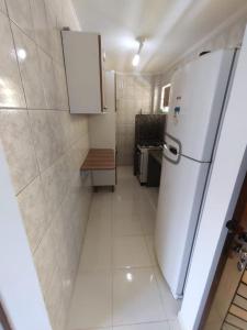 a small kitchen with a white refrigerator in it at Apartamento Martin de Sá in Caraguatatuba