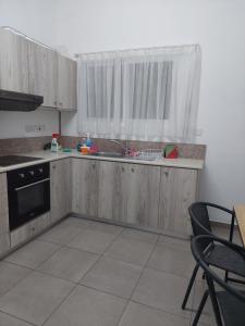 a kitchen with wooden cabinets and a window at White house 3 bedroom City Center in Limassol