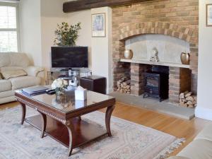 a living room with a fireplace and a coffee table at The Farmhouse in Hampreston