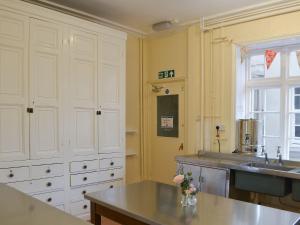 una cocina con armarios blancos y fregadero en Blaithwaite House en Blencogo