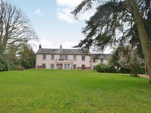 a large white house with a large green yard at Blaithwaite House in Blencogo