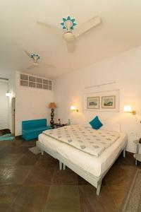 1 dormitorio con 1 cama grande con almohadas azules en Mango Tree Courtyard Dehradun, en Dehradun