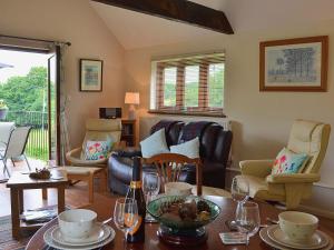 a living room with a table and chairs at Swallows Barn in Dallington