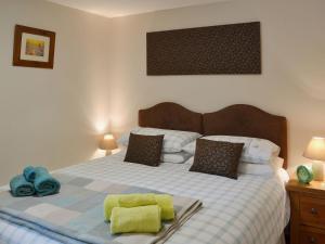 a bedroom with a bed with yellow towels on it at Swallows Barn in Dallington