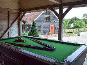 a pool table with two cuesticks on top of it at Swallows Barn in Dallington