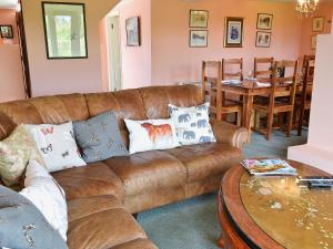 a living room with a brown leather couch and a table at Oldfield in Warminster