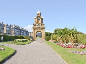 a clock tower in the middle of a garden at South Cliff Sands Ii in Scarborough