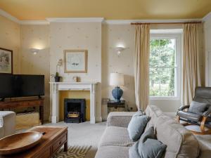 a living room with a couch and a fireplace at Holly House in Pooley Bridge
