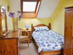 Schlafzimmer mit einem Bett, einem Schreibtisch und einem Fenster in der Unterkunft Eaton Barn in Burmarsh