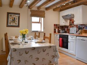 una cocina con una mesa con flores. en Brampton Hill Farm Cottage, en Madley