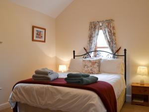 - une chambre avec un lit et des serviettes dans l'établissement Brampton Hill Farm Cottage, à Madley