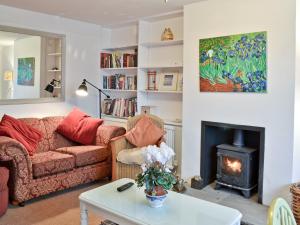 uma sala de estar com um sofá e uma lareira em Cedars em Fordwich