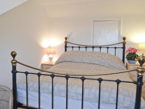 a bedroom with a bed with two lamps and flowers at Cedars in Fordwich