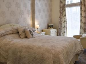 ein Schlafzimmer mit einem großen Bett und einem Fenster in der Unterkunft The Secret Garden in Windermere