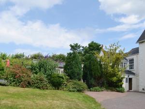 a house with a yard with bushes and trees at The Orangery in Bideford