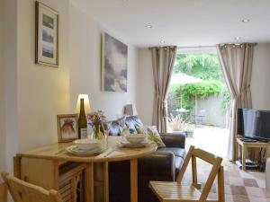 uma sala de estar com uma mesa e um sofá em Field View Cottage em Bruisyard