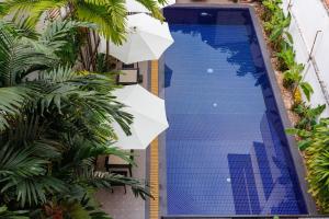 een bovenaanzicht van een zwembad met een parasol bij Siem Reap Urban Boutique Hotel in Siem Reap