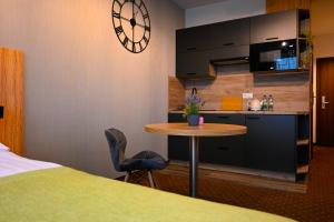 una camera con letto e tavolo e una cucina di Zielone Apartamenty z aneksem kuchennym a Legnica