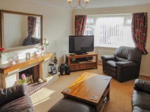 a living room with a fireplace and a television at 24 Steed Close in Goodrington