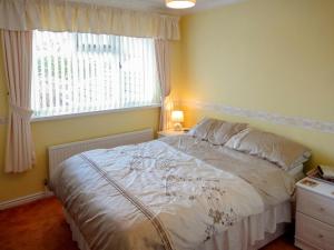 a bedroom with a white bed with a window at 24 Steed Close in Goodrington