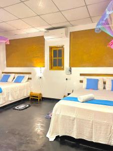 Habitación con 2 camas en una habitación en Tusker's Paradise Safari Villa en Udawalawe