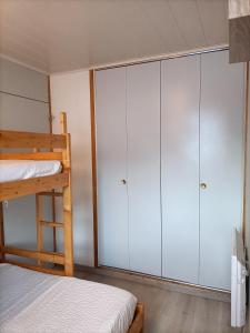 a bedroom with white cabinets and a bunk bed at Au Bord des Pistes in La Plagne