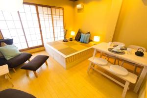 een kamer met een bed en een tafel en stoelen bij Cha Cha An in Osaka