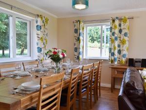 a dining room with a table and chairs and windows at Baswick Steer in Burshill