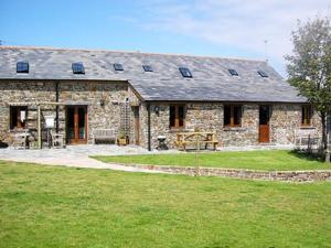 a large stone house with a green lawn in front of it at Spekes Retreat - 18827 in Milford