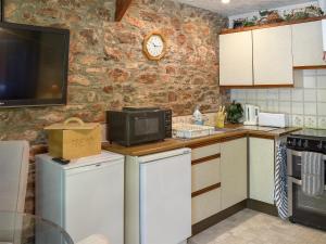 eine Küche mit Mikrowelle und Arbeitsplatte in der Unterkunft The Garden Room - 15536 in Marldon