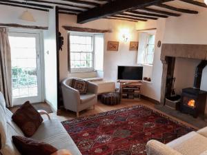 a living room with a couch and a fireplace at Chapel Cottage in Askham