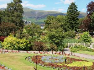 a garden with a flower bed with mountains in the background at Alvamere in Keswick