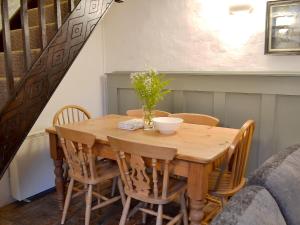 a dining room table with chairs and a wooden table at Lamont Cottage in Niton