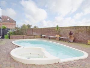 a large swimming pool in a brickickedicked yard at Hobland Barn in Belton