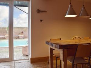 a dining room with a table and a pool at Hobland Barn in Belton