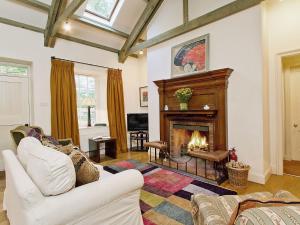 a living room with a fireplace and a white couch at Stables Cottage-uud in Corsock