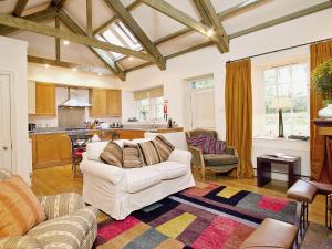 un soggiorno con divano bianco e una cucina di Stables Cottage-uud a Corsock
