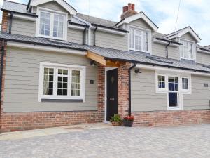 a brick house with a black door at Pettaugh Lodge in Debenham