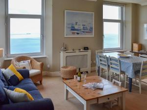 a living room with a blue couch and a table at Tamarisk in Coverack