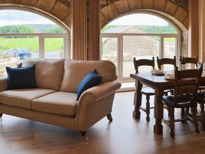 a living room with a couch and a table at The Byres in Greenhaugh