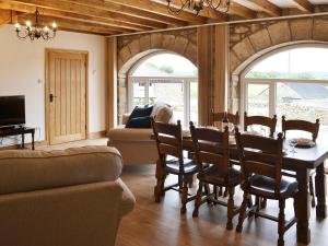 a living room with a table and chairs and a couch at The Byres in Greenhaugh