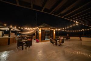 a restaurant with people sitting at tables and lights at Seeya Hotel in Tubigon