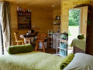 ElmstedにあるByre Cottage - 29410のベッド付きの部屋、キャビン内のキッチンを提供しています。