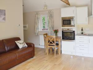 a living room with a couch and a table at Dairy Cottage in Bodmin