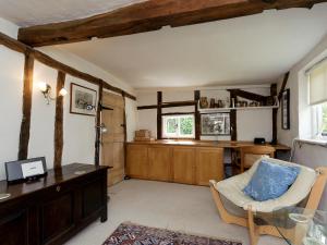 a living room with a table and a chair and a desk at Thatched Cottage in Saxmundham