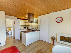 een keuken en een woonkamer met een klok aan de muur bij Strawberries And Cream in Bowness-on-Windermere