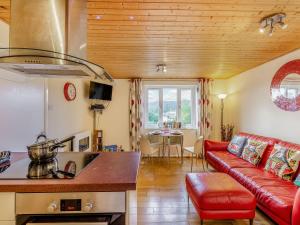 a kitchen and a living room with a red couch at Strawberries And Cream in Bowness-on-Windermere