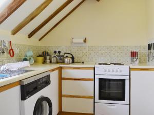 a kitchen with a white stove and a dishwasher at The Oast House in Boraston