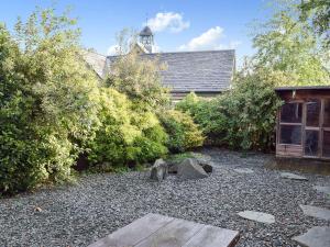 ogród z kamieniami i drzewami oraz budynek w obiekcie Croft Cottage w mieście Braithwaite