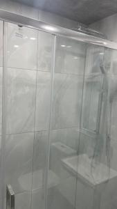 La salle de bains est pourvue d'une douche avec une porte en verre. dans l'établissement POTTERS LODGE by Edl Ventures Ltd, à Manchester
